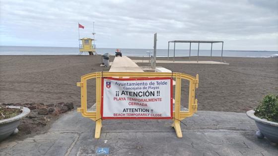 Skilt foran strand med teksten midlertidig stengt på spansk.