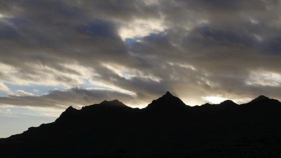 Silhuett av fjellkjede mot himmel. 