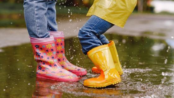 To barn med gummistøvler i vannpytt.