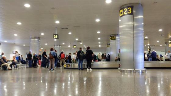 Passagerare väntar på sitt bagage på flygplatsen.