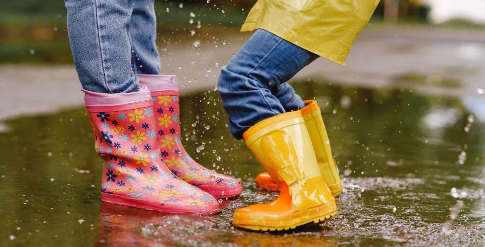 To barn med gummistøvler i vannpytt.