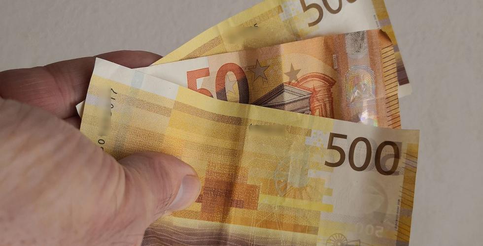 hånd holder pengesedler